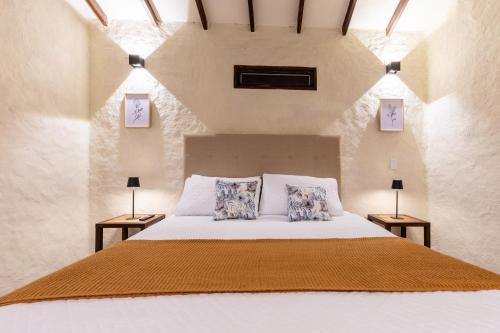 a bedroom with a white bed with two night stands at Eco Lodge Glamping in Guatapé