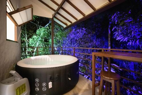 a jacuzzi tub on a deck with a table at Eco Lodge Glamping in Guatapé