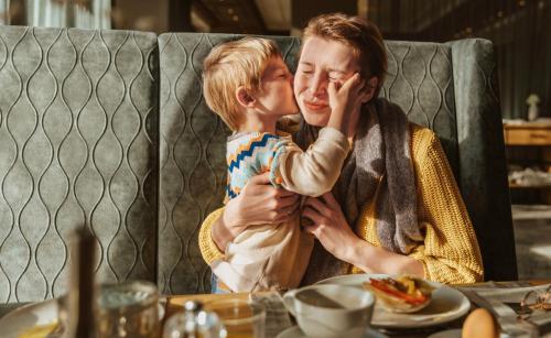 a man and a boy sitting at a table at Holiday Inn Cottbus by IHG in Cottbus