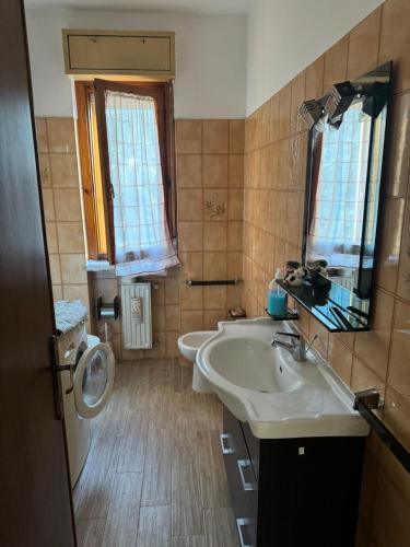 a bathroom with two sinks and two windows at Casa di Anna in Graffignano
