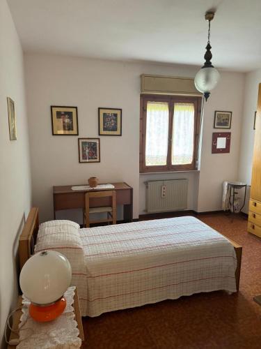 a bedroom with two beds and a desk and a window at Casa di Anna in Graffignano