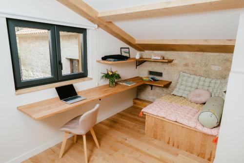 a small room with a desk and a bed with a laptop at iSlow Costa da Morte in Laxe