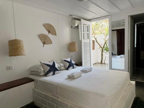 a white bedroom with a large bed with towels on it at Peixe Crew Centro in Búzios