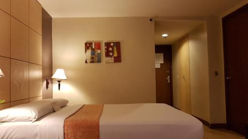a bedroom with a large bed in a room at Riviera Mansion Hotel in Manila