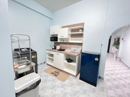 a kitchen with white cabinets and a blue refrigerator at S Home Hat Yai - Entire House, Private Parking in Hat Yai