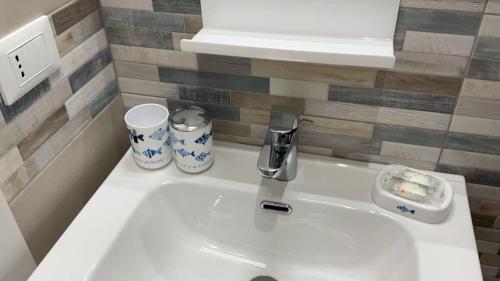 a white sink in a bathroom with two cups at Casa di Leo in Loano