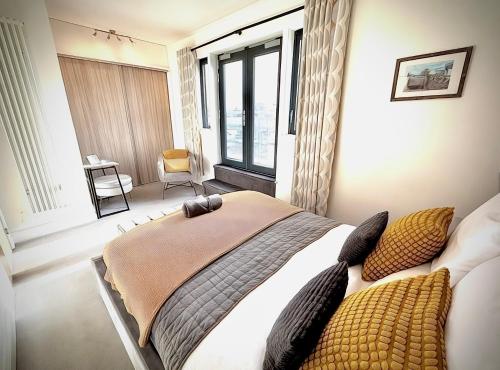 a bedroom with a bed with pillows and a window at Margate Penthouse Private Balconies Sea Glimpses Gated Parking Air-Con The Penthouse Margate in Margate