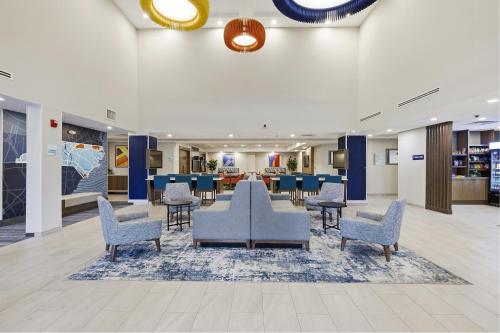 a lobby with chairs and a waiting area at Holiday Inn Express & Suites Raleigh West - Lenovo Center by IHG in Raleigh