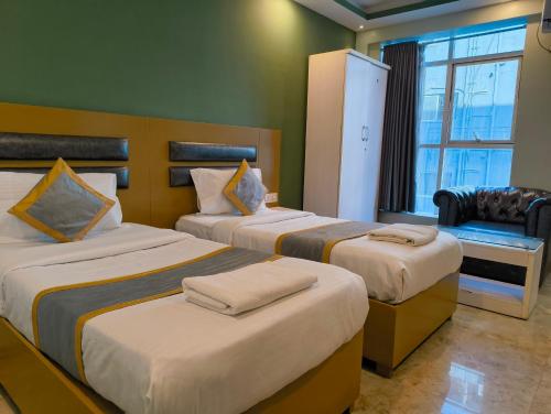 a hotel room with two beds and a window at Hotel Cozzy Inn in Bangalore