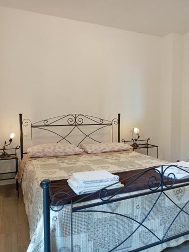 a bed with a metal frame with two towels on it at Appartamento Taggiasca con piscina - Riva Trigoso in Sestri Levante