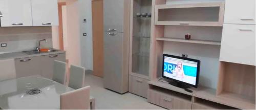 a kitchen with a table and a tv in a room at Alisia Apartment in Rossano Stazione