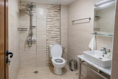 a bathroom with a toilet and a sink and a shower at Къща за гости Касида in Sapareva Banya