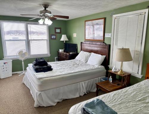 a bedroom with two beds and a ceiling fan at The Wellington Lake Cottage in Middlebury