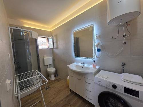 a bathroom with a sink and a washing machine at Tonino Apartment in Pag