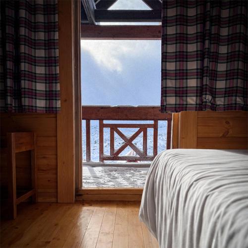 a bedroom with a view of the ocean from a window at Chalé do Zêzere in Cortes do Meio