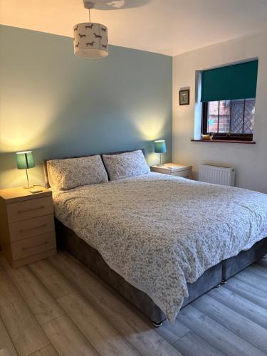 a bedroom with a bed and two lamps and a window at Grooms cottage in South Collingham