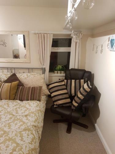 a bedroom with a bed and a chair and a mirror at Nannys tiny hoose in Inverness