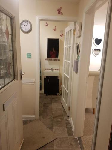 a hallway with a door and a clock on the wall at Nannys tiny hoose in Inverness