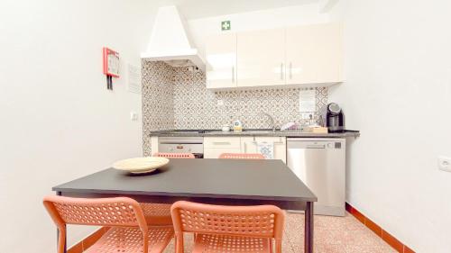 a kitchen with a black table and two chairs at Casa Sebastião in Faro