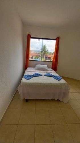 a bedroom with a large bed with a window at Pousada Sol e Mar in Saubara