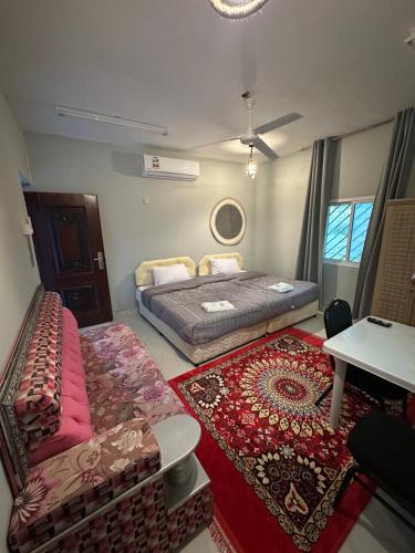 una camera da letto con un letto, un divano e un tavolo di Blue star inn a Al Ḩamrāʼ
