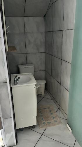 a small bathroom with a sink and a toilet at Pousada Azambuja in Cidreira
