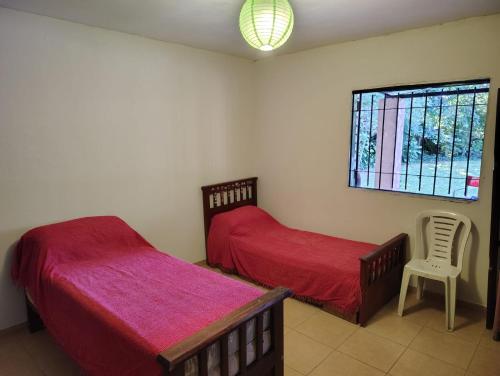 a bedroom with two beds and a window at CASA QUINTA Sasha in Sauce Viejo