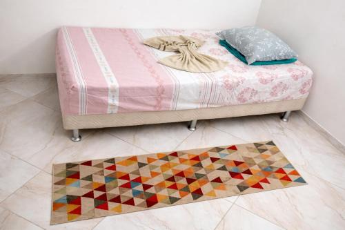 a bedroom with a bed with a rug on the floor at Quarto privado simples para o público masculino em acomodação compartilhada in Serra