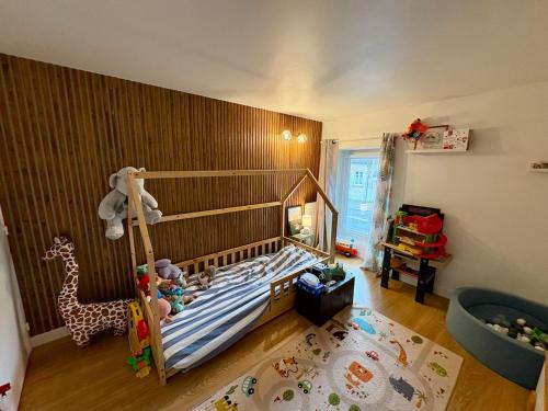a bedroom with a bed with a giraffe and a crib at Chez Audrey & Bastien in Dinan