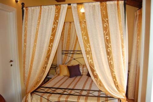 a canopy bed with curtains in a bedroom at Villa Vitalina in Ghivizzano