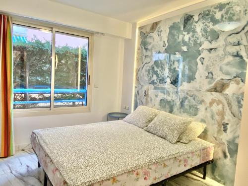 a bedroom with a bed and a rock wall at Beach and Sea View in Roquebrune-Cap-Martin