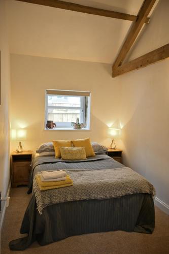 a bedroom with a bed with two night stands at Stunning Barn Conversion next to Horse Field sleeps 10 in Morpeth