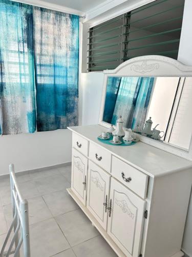 a bathroom with a mirror and a white dresser at Dolce Vita Emilia in Sainte-Luce