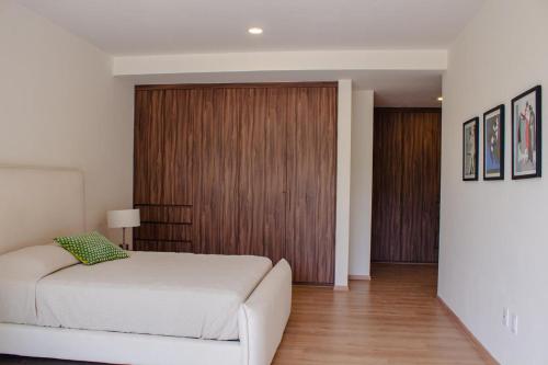 a bedroom with a bed and a wooden door at Casa feliz 2 in Oaxaca City