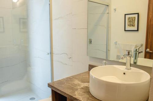 a white bathroom with a sink and a shower at Casa feliz 2 in Oaxaca City