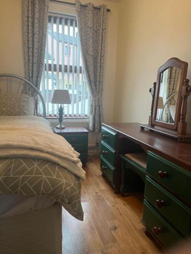 a bedroom with a bed and a dresser with a mirror at Cierons château in Derry Londonderry
