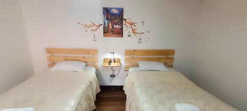 two beds in a small room withermottermottermott at Anais y Nicolas Cusco in Cusco