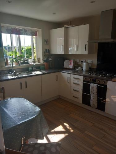 a kitchen with a sink and a stove top oven at Beautiful detached home in Evesham