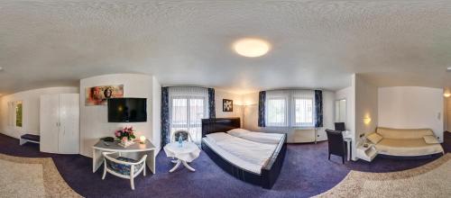 a bedroom with a bed and a table and a tv at Hotel Gasthof Traube in Kernen