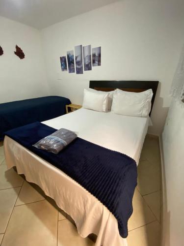 a large bed with a blue blanket on top of it at Suítes no centro Histórico Diamantina in Diamantina