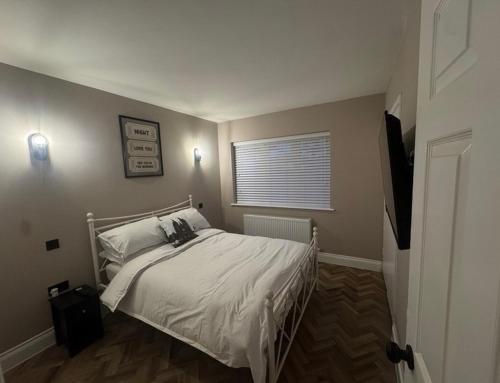 a bedroom with a white bed with a window at Entire Flat in Lichfield City Centre in Lichfield