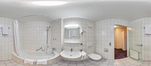 a white bathroom with a tub and a sink at Hotel Gasthof Traube in Kernen