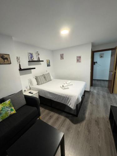 a hotel room with a bed and a couch at Rooms Capulino in Málaga