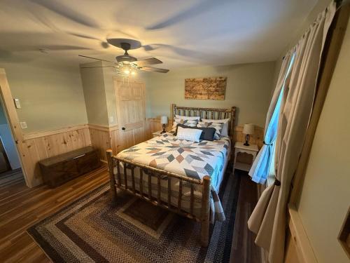 a bedroom with a bed and a ceiling fan at Cattail Cabin in Waterville