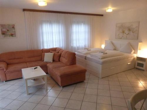 a living room with a couch and a bed at Winzergasthof zum Kellerstübchen in Mehring