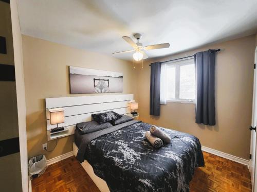 a bedroom with a bed and a ceiling fan at Cozy 3-Bedroom Haven, Private Pool & Parking ! in Longueuil