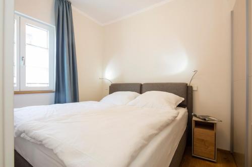 Schlafzimmer mit einem großen weißen Bett und einem Fenster in der Unterkunft Haus Nordland in Juist
