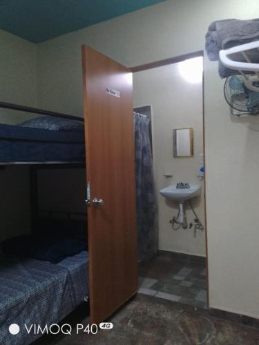 a door to a room with a sink and bunk beds at El Cubanito Cafe y hospedaje in León