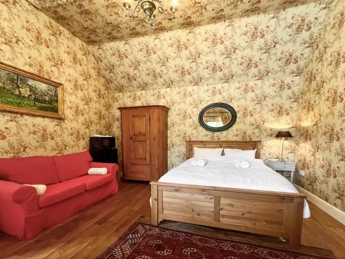 a bedroom with a bed and a red couch at Cottage 2 - Uk46612 in Broughton