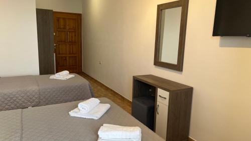a hotel room with two beds and a mirror at VANGJELIS HOTEL in Himare